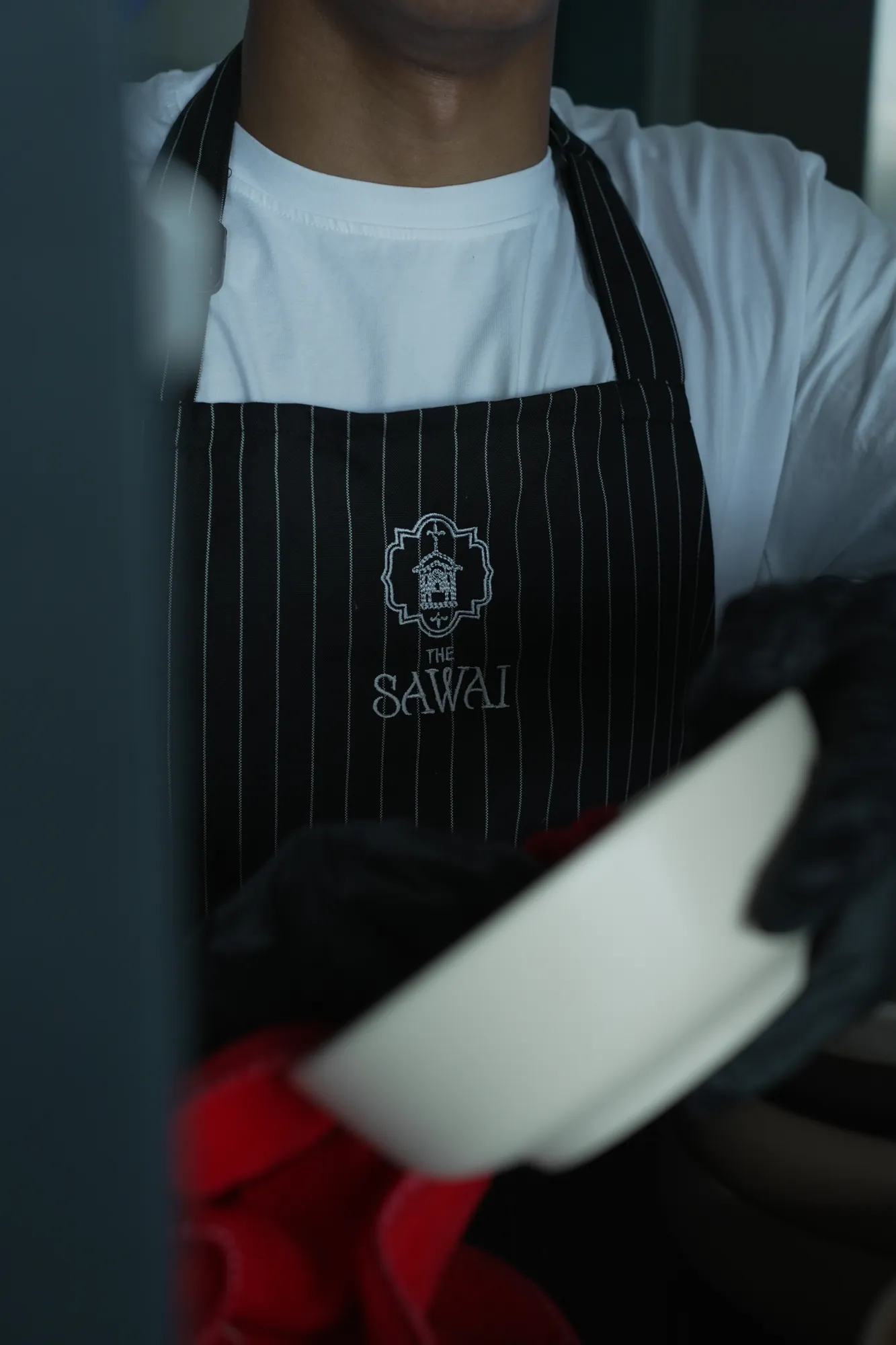The Sawai monogram on a server's apron