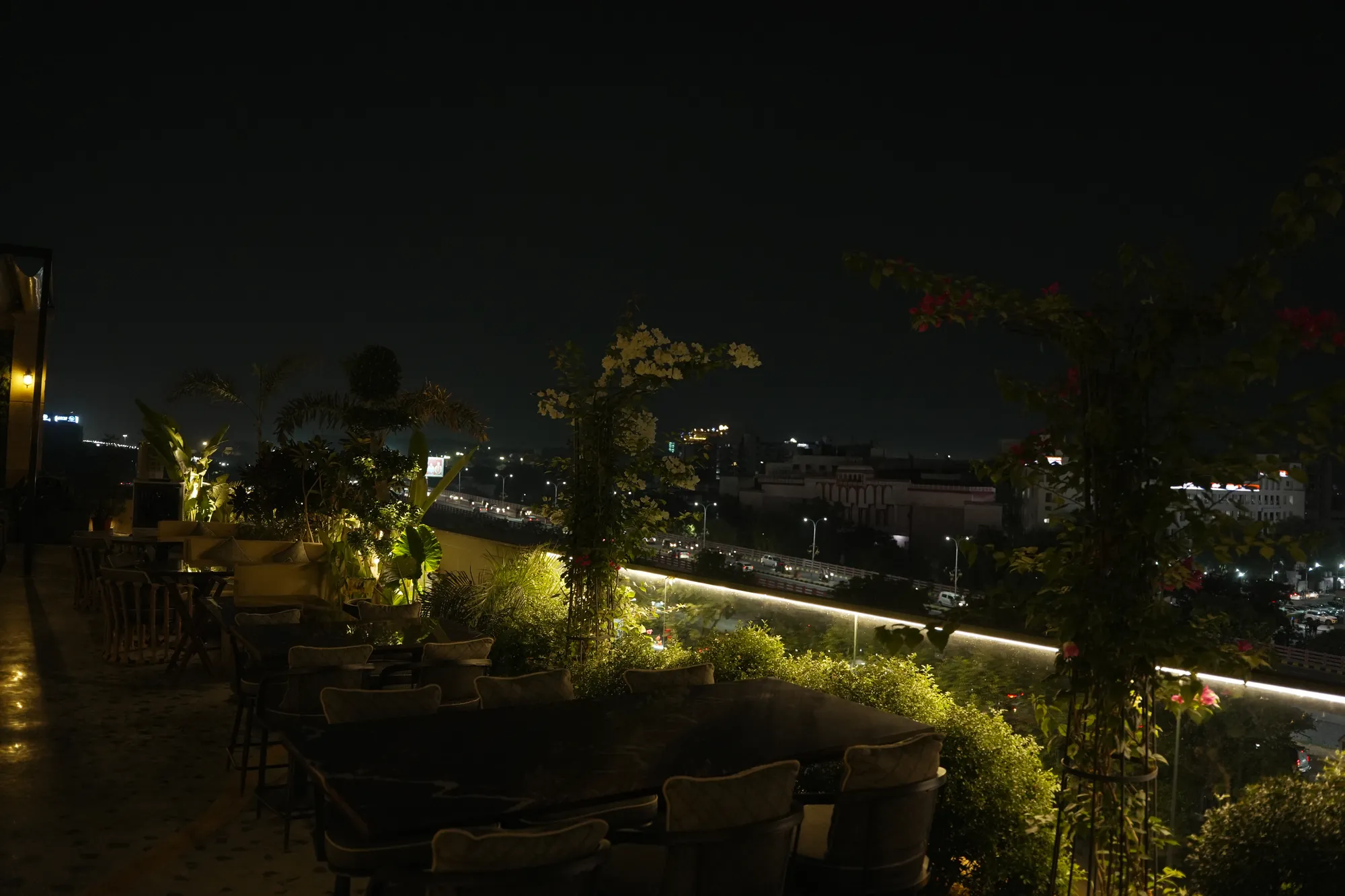 The rooftop garden at night, a ribbon of light along the planters