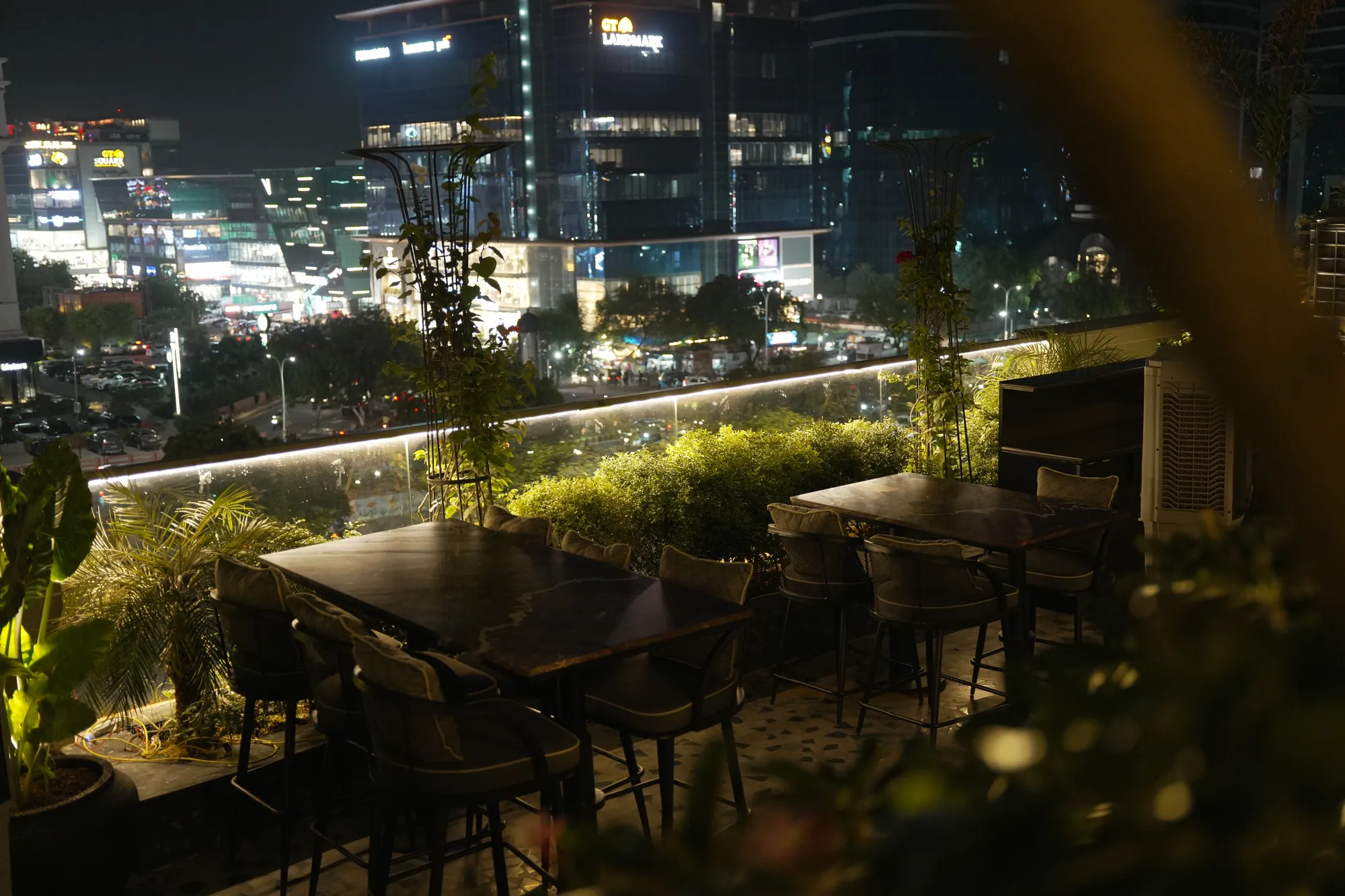 Rooftop tables in the garden, the city lit up beyond